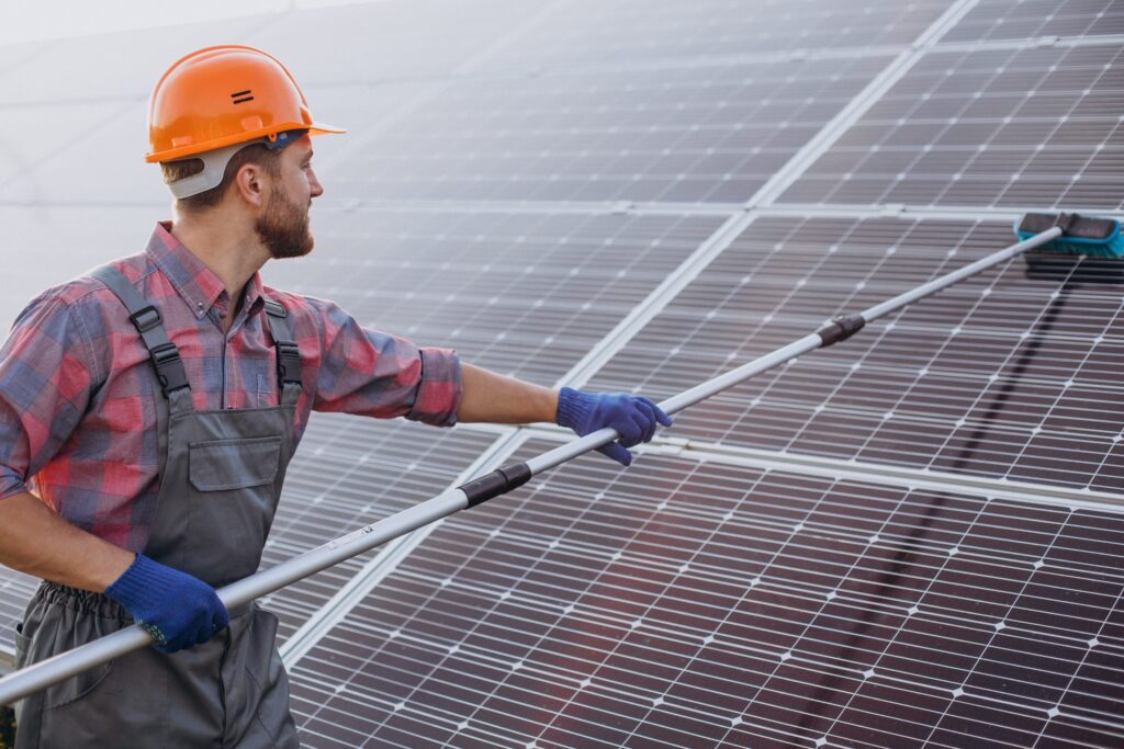 male-worker-cleaning-solar-panels-min